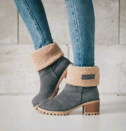 Women's black suede mid-tube snow boots with a round toe and thick low heel on a waterproof platform.