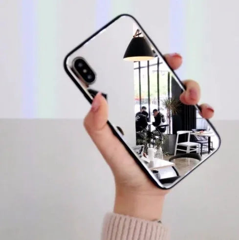 Black iPhone mirror phone case showing reflective surface on back, compatible with iPhone X and other models.