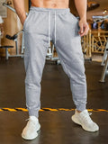 Men's loose-fit linen-look leisure trousers with a drawstring elastic waist in a light colour.