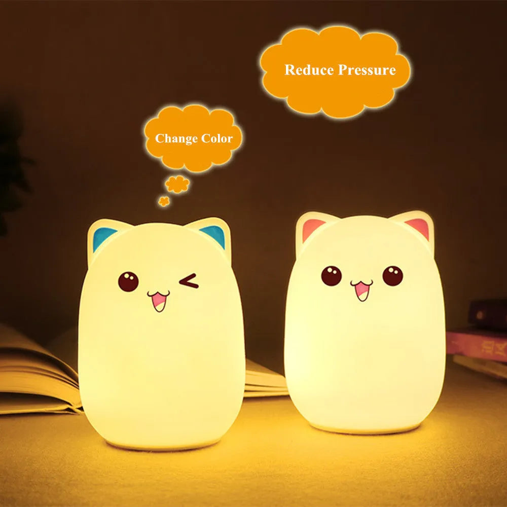 Cartoon silicone clap lamp in blue with warm white light mode on a wooden bedside table