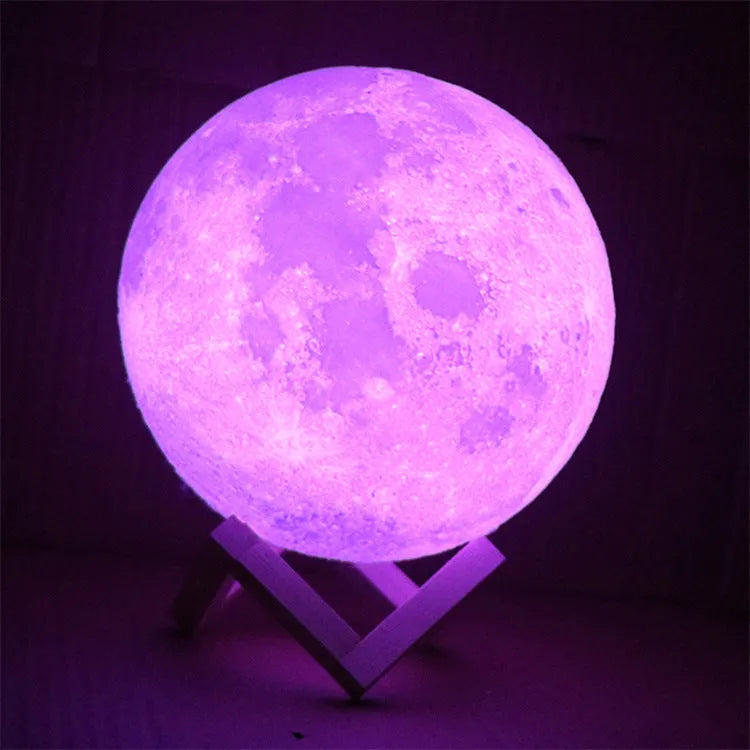 3D printed moon lamp glowing on a wooden stand with touch ring at base