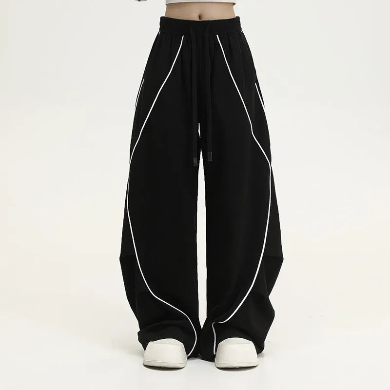 Black striped hip hop trousers with wide-leg pleated design showing mid-waist styling