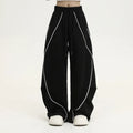 Black striped hip hop trousers with wide-leg pleated design showing mid-waist styling