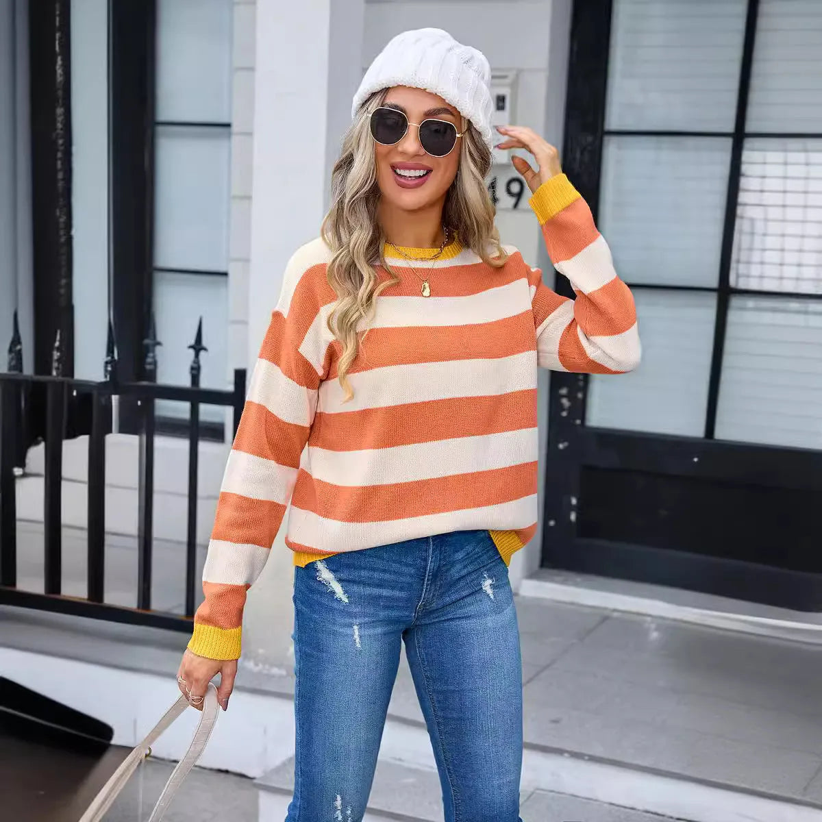 Women's loose fit long sleeve striped sweater in blue colour on a hanger.