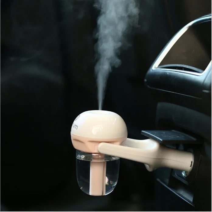 Compact blue car humidifier with rotation nozzle and essential oil diffusion capability on car dashboard