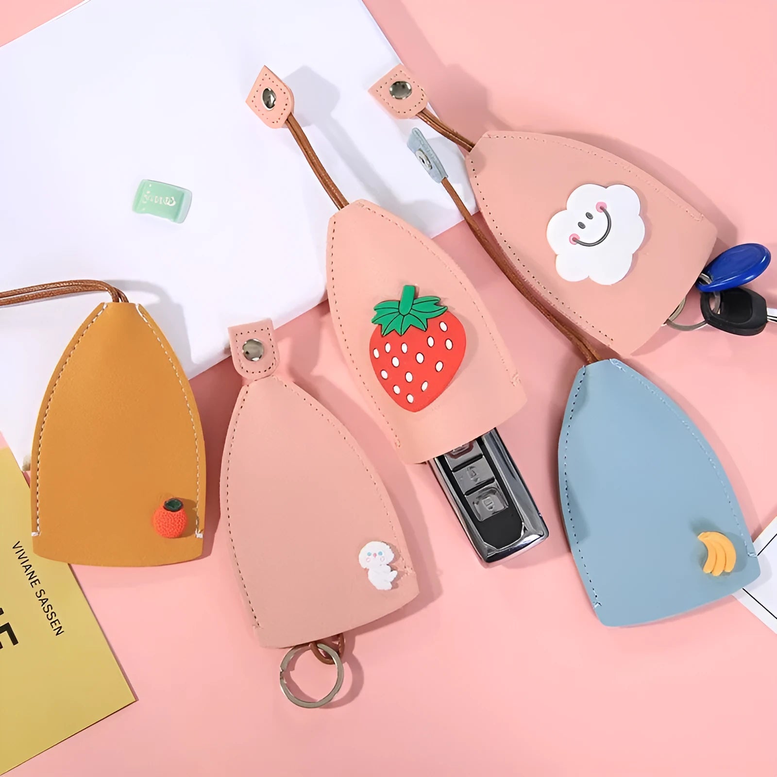 Colourful cartoon pull-out key protector case made from PU leather, showing a selection of fruit and animal designs.