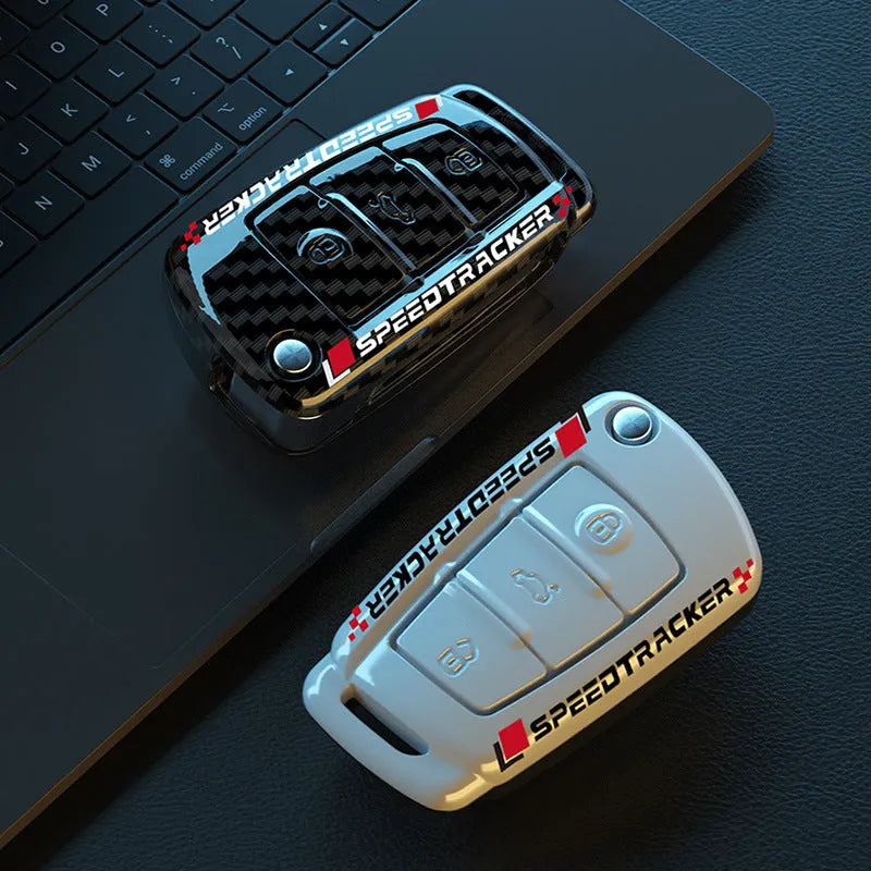 Carbon fibre pattern car key cover with a small rectangular mirror set into the feilin material casing.