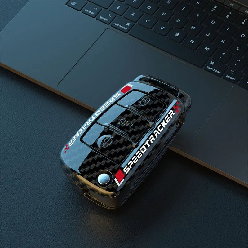 Carbon fibre pattern car key cover with a small rectangular mirror set into the feilin material casing.