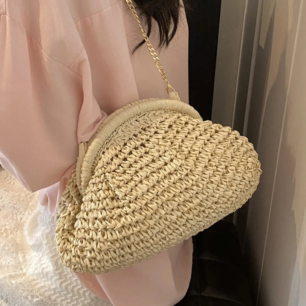 Shell-shaped straw shoulder bag with chain detailing and internal zipper pocket