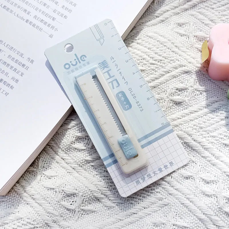 Small plastic blade art knife in blue, shown next to a ruler showing its 7.2cm length.