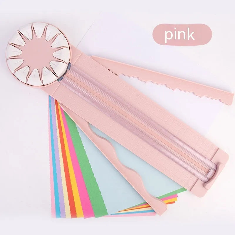 Pink 12-in-1 paper cutting machine with interchangeable blades for scrapbooking on white background