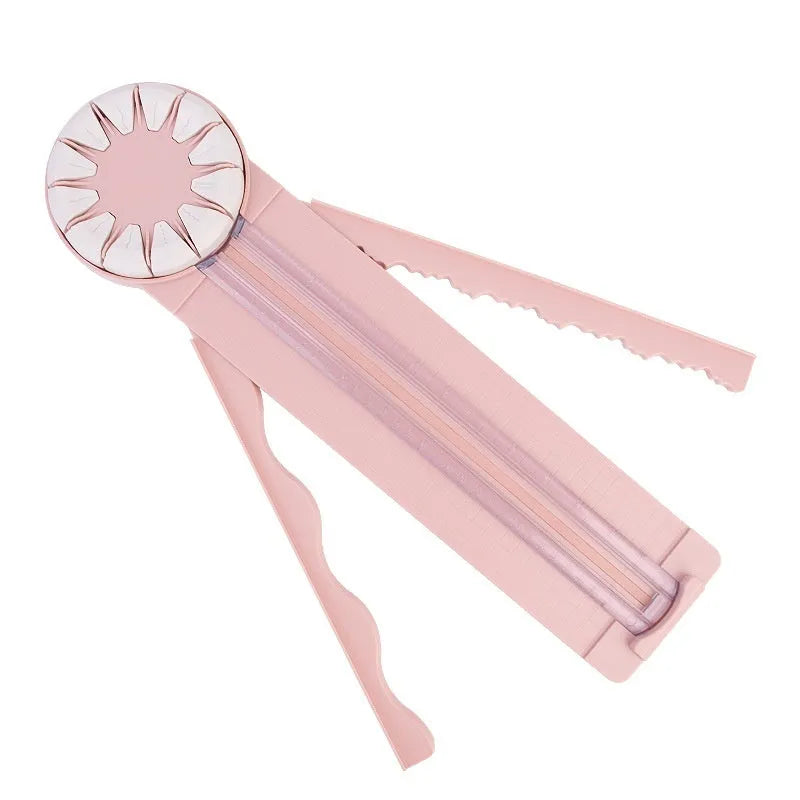 Pink 12-in-1 paper cutting machine with interchangeable blades for scrapbooking on white background