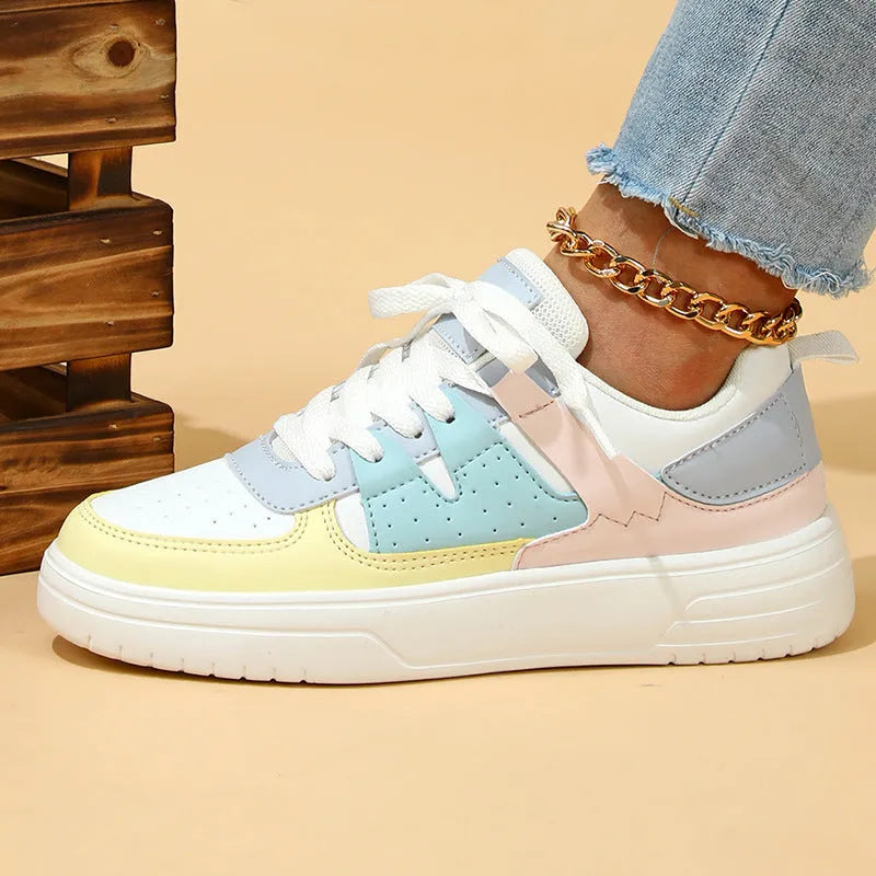 Trendy platform sneakers with white and yellow moon colour block, cross straps, and lace-up closure on a light background