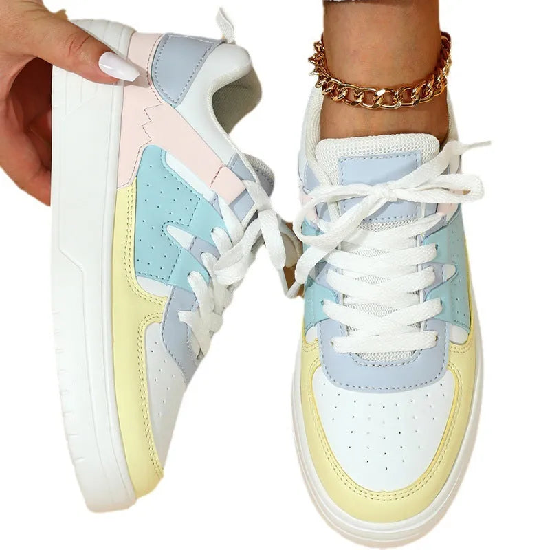 Trendy platform sneakers with white and yellow moon colour block, cross straps, and lace-up closure on a light background
