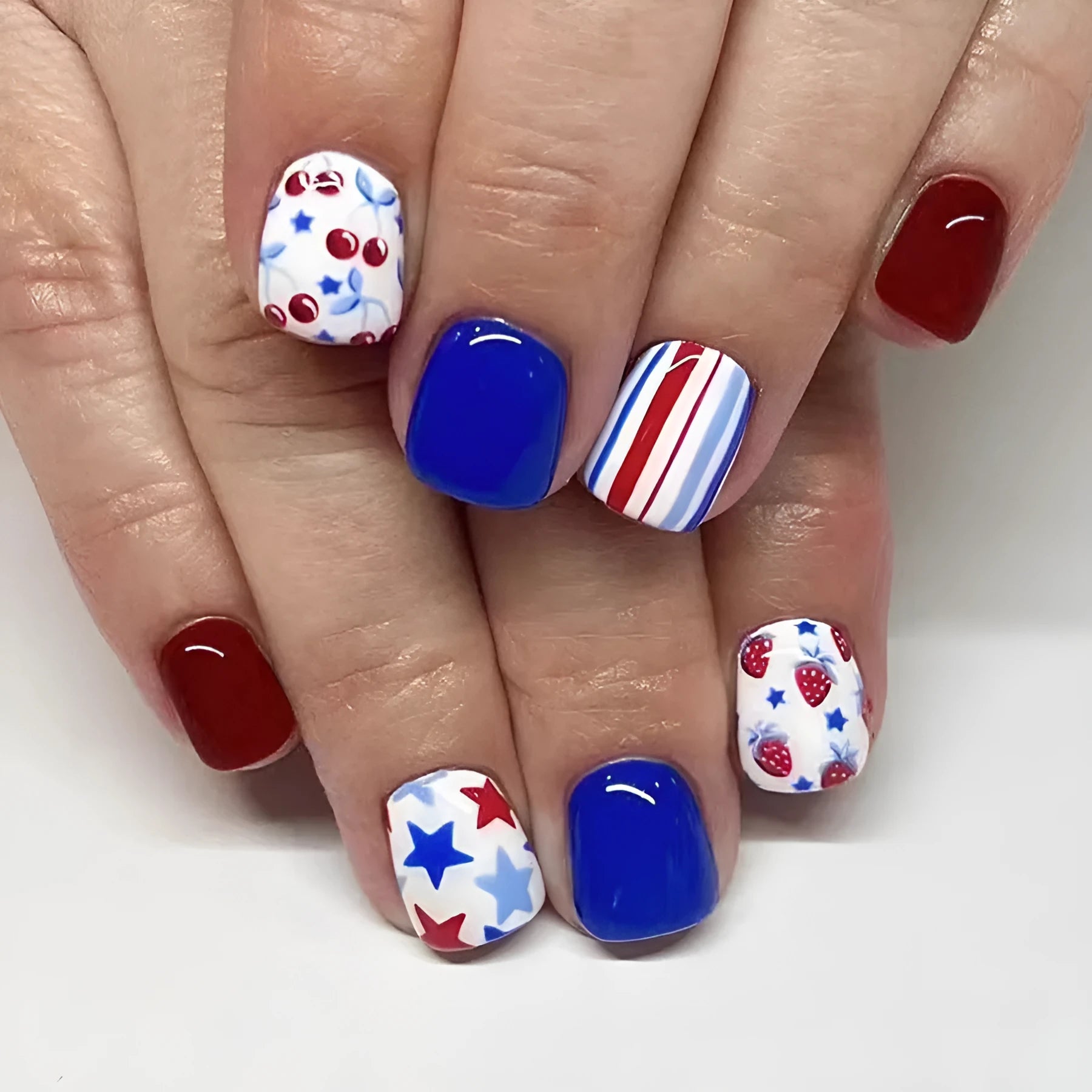 Short glossy red and blue nail stickers with strawberry and cherry patterns - 24 piece set
