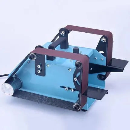 Blue desktop dual-axis belt sander with 750W motor and knife sharpener accessory on workbench