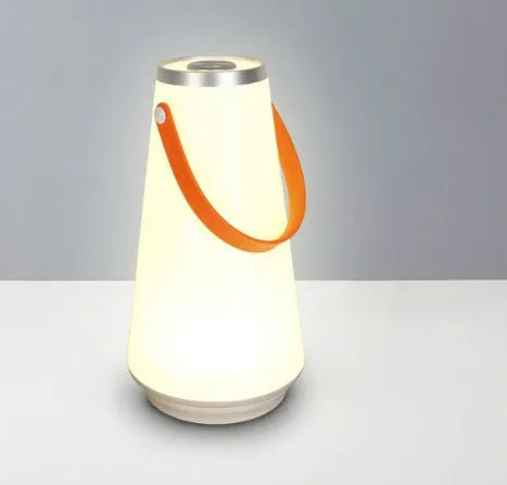 White rechargeable LED bedside table lamp with USB cable on a wooden surface.