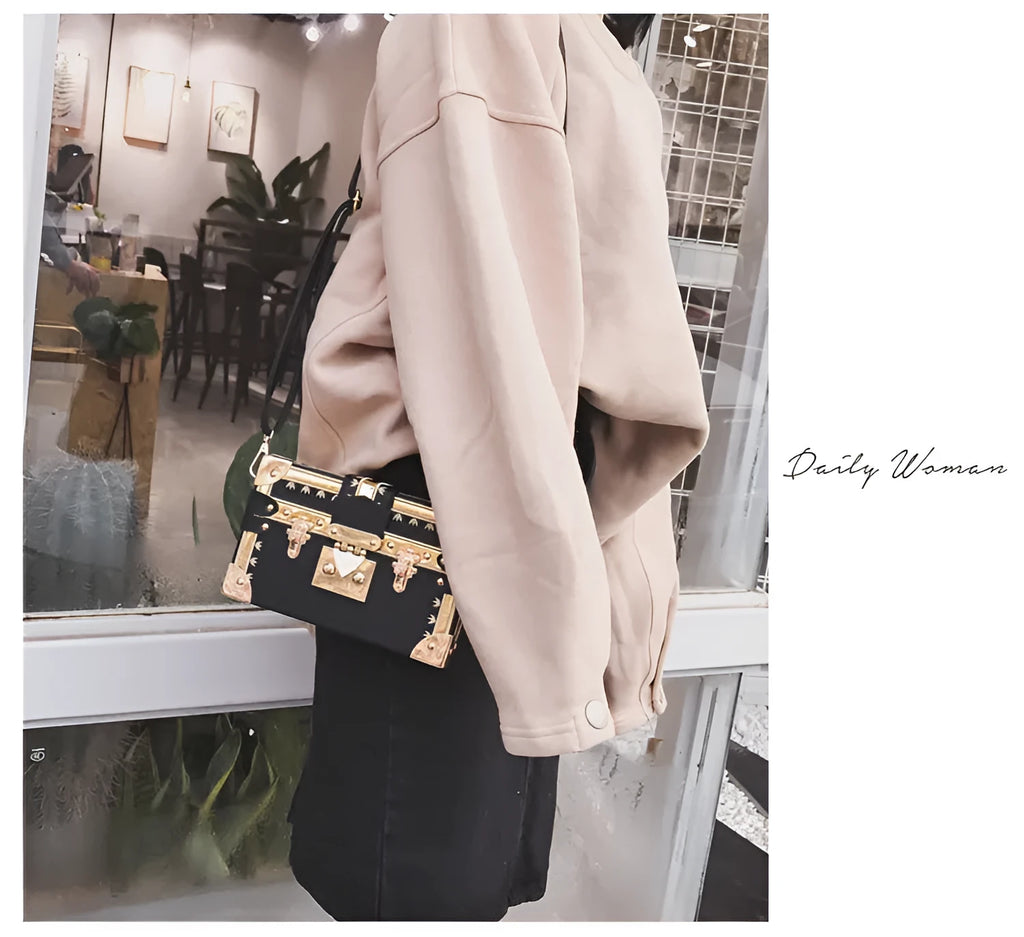 Women's black hard case shoulder bag with flap closure and single strap