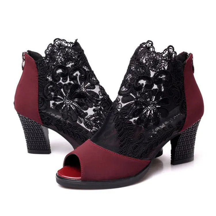 Women's black lace-up gladiator sandals with a square high heel and decorative floral detail on the peep toe