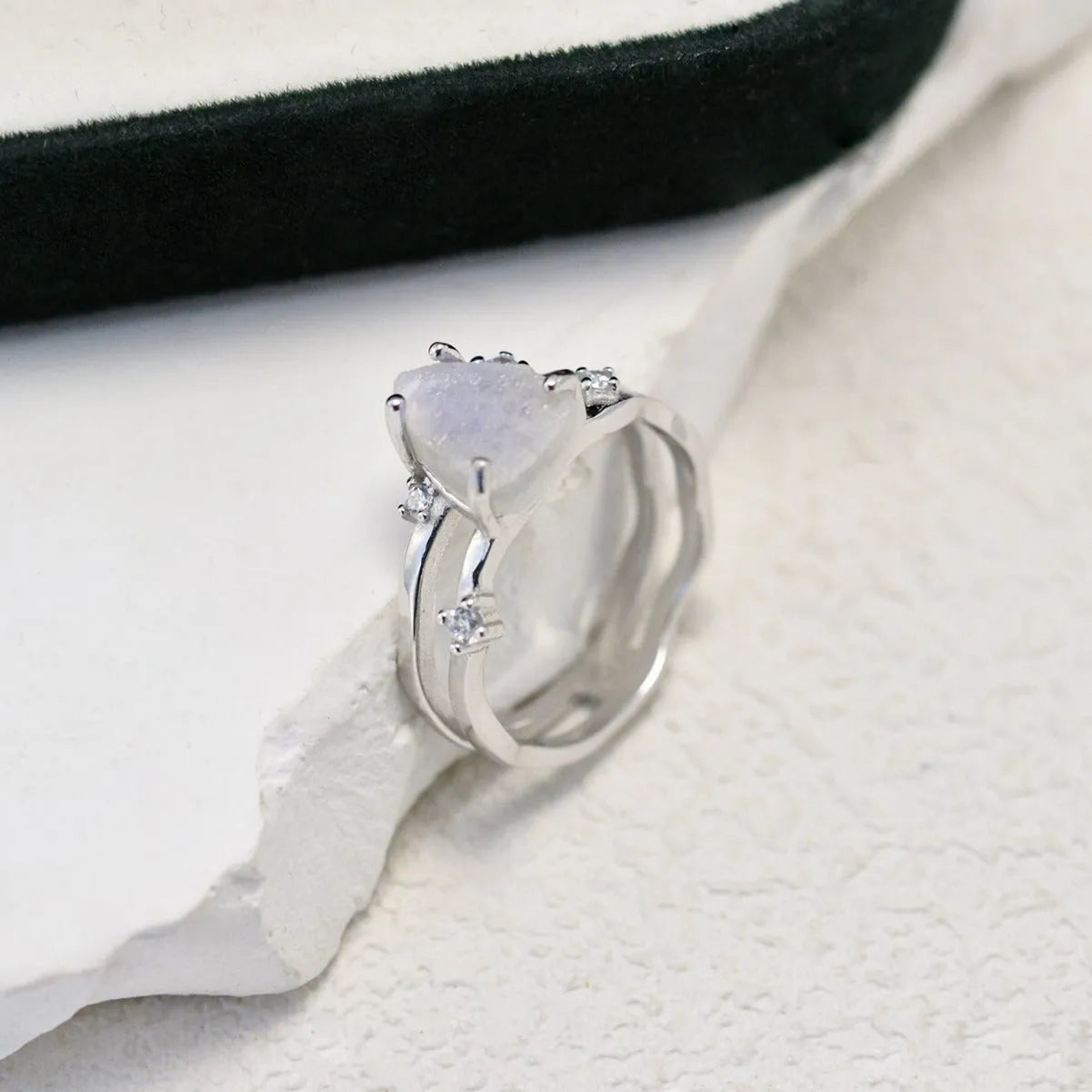 S925 silver ring with an irregular triangle shape holding a moonstone, shown in a rose gold electroplated finish.