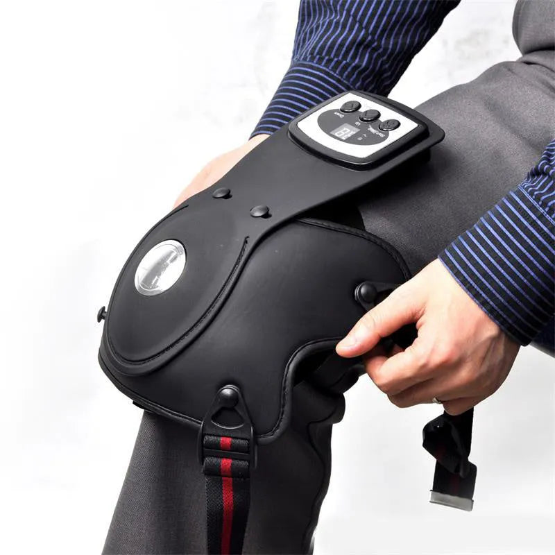 Infrared heat therapy knee and shoulder massager with pads and power adapter on a table.
