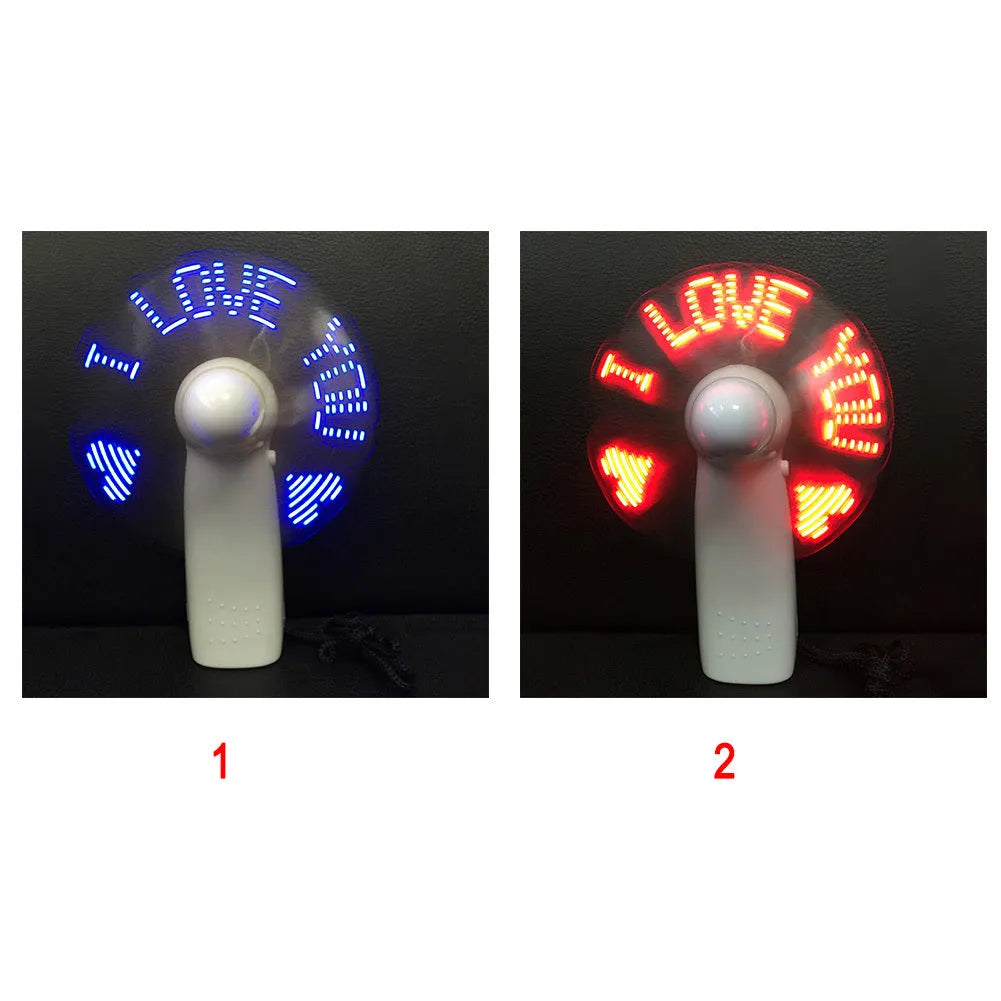 White handheld mini fan showing blue and red LED 'I Love You' pattern, held in hand.