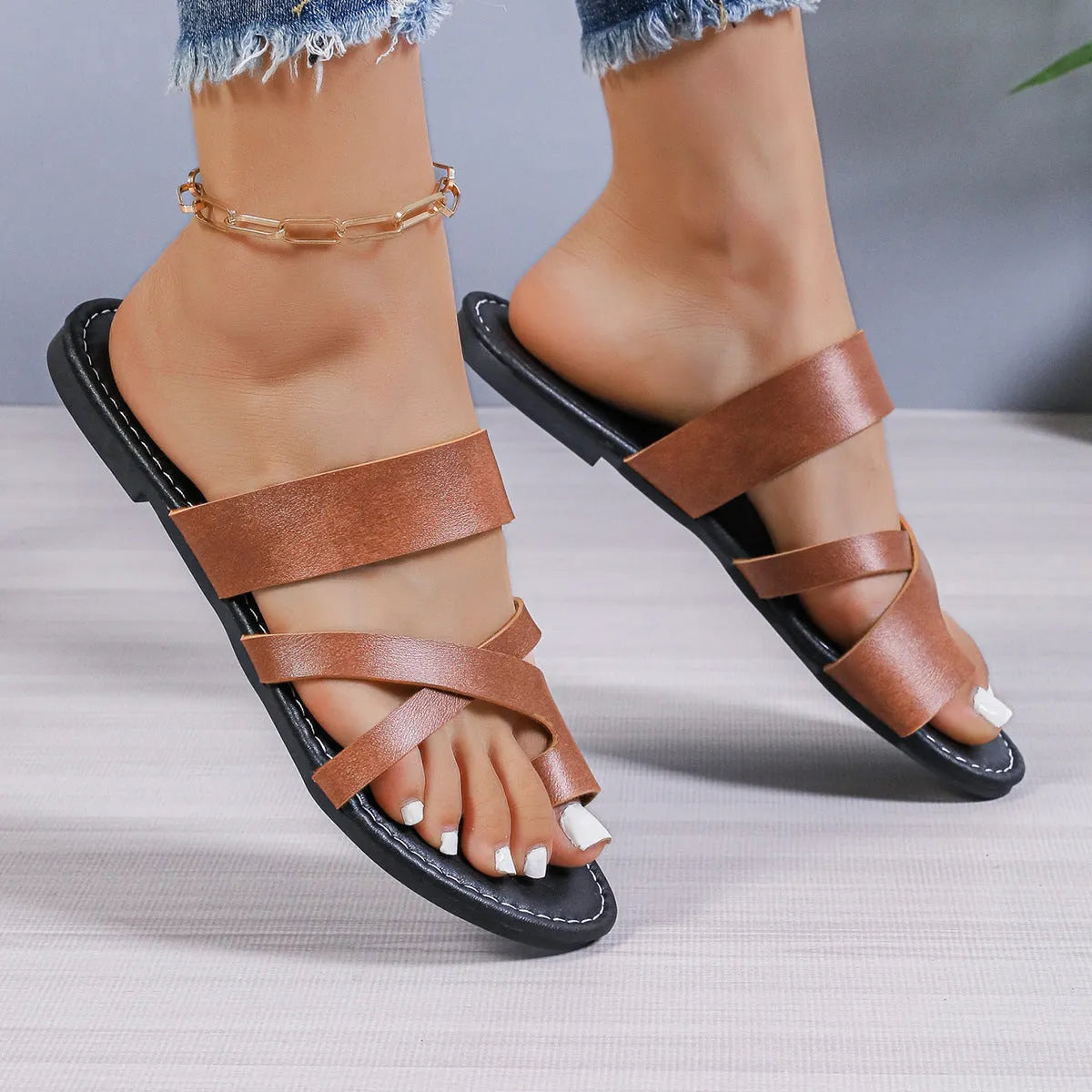 Adult beach slippers in black with a hollow-out design, artificial PU upper, and rubber sole.
