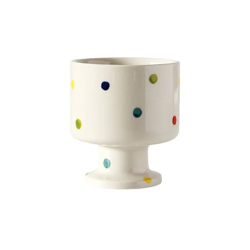 Hand-pinched irregular shaped ceramic mug in a solid colour, shown on a table.