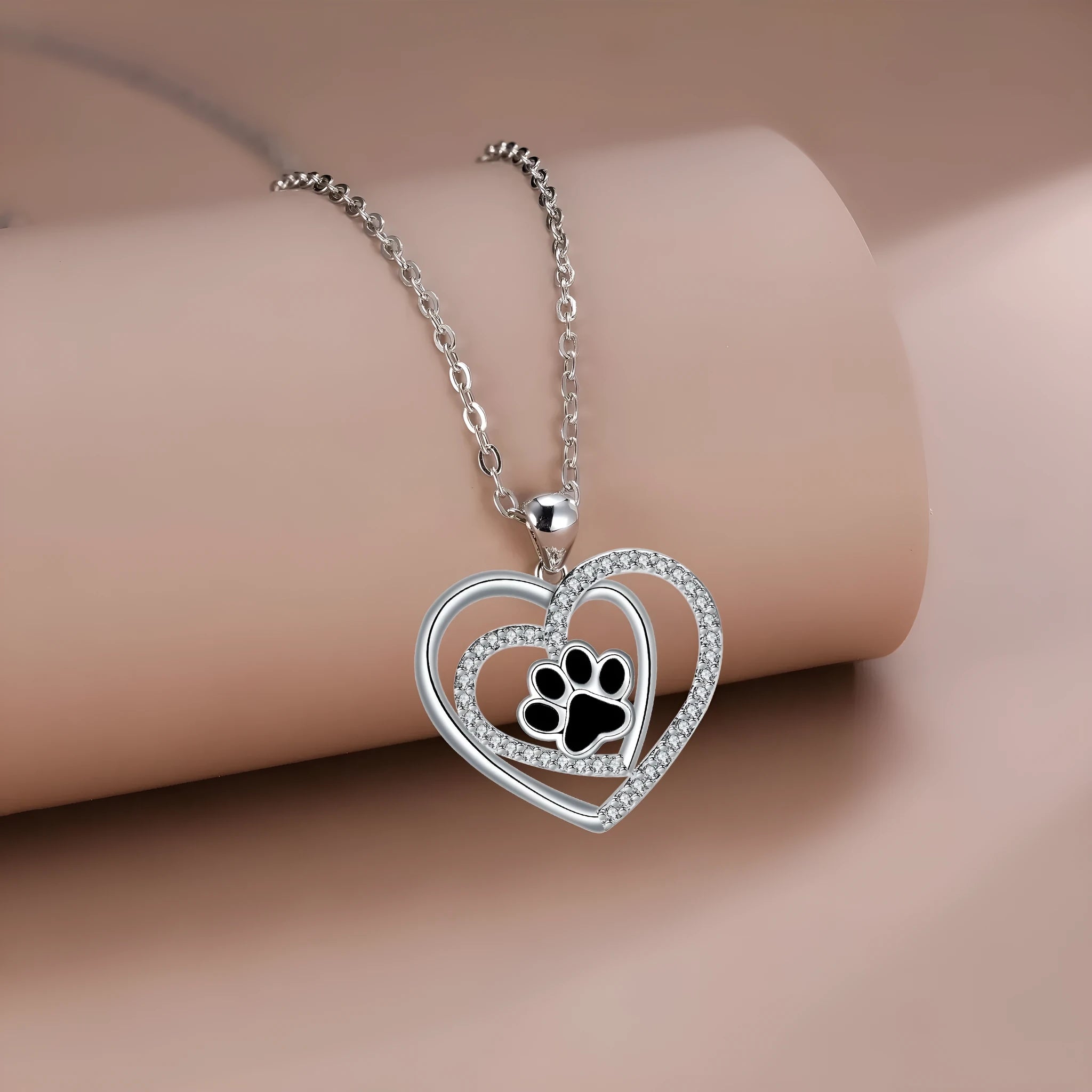Close-up of a women's copper necklace with a heart-shaped dog's paw print pendant.