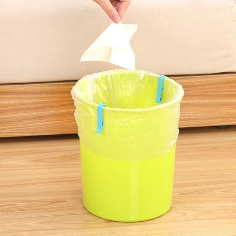 White PP plastic garbage bag fixing clip attached to the rim of a black indoor bin.