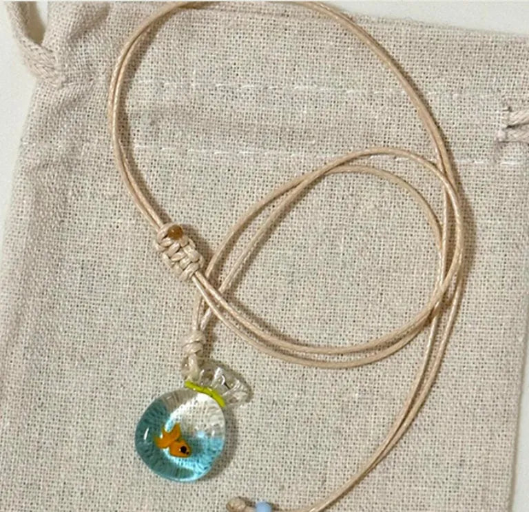 Women's joker pendant necklace with coloured glaze ornament on a cotton and linen clavicle chain.