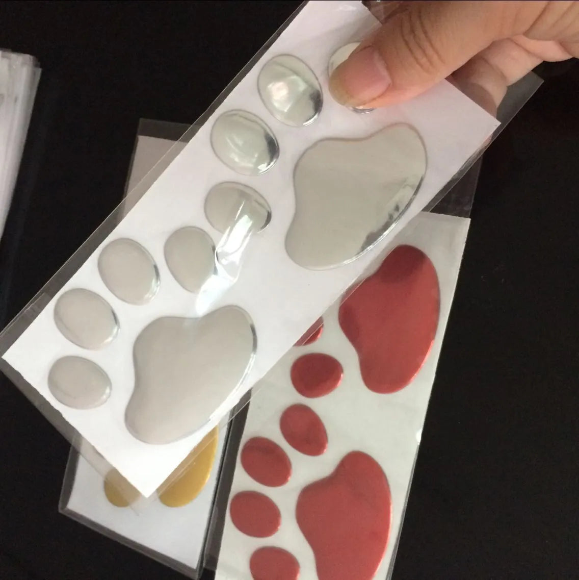 Pair of hand-shaped dog footprint car stickers in four colour options, each 7 cm long.