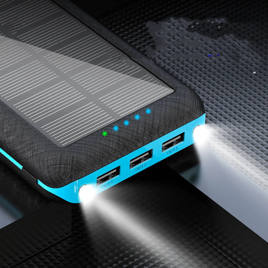 Black portable solar power bank with wireless charging pad and three USB ports on a wooden surface.