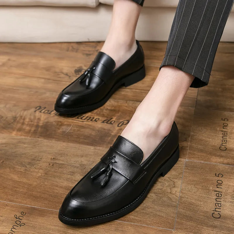 Men's black and brown tassel loafers with a slip-on design and rubber sole for business casual wear.