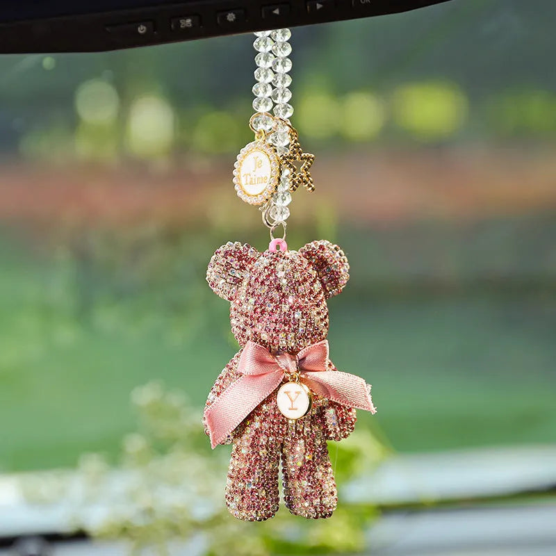 Close-up of a crystal rhinestone Violent Bear ornament on a car rearview mirror.