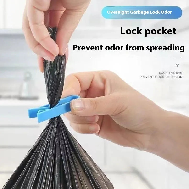 White PP plastic garbage bag fixing clip attached to the rim of a black indoor bin.