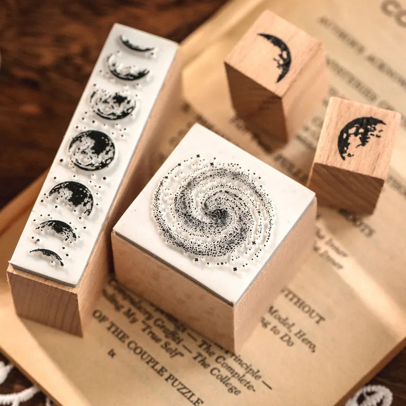 Wooden decorative stamp set with seven hand-carved botanical or celestial designs for paper crafts