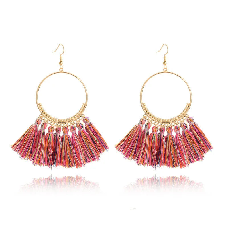 Big round drop dangle earrings in hand-woven geometric alloy design on white background