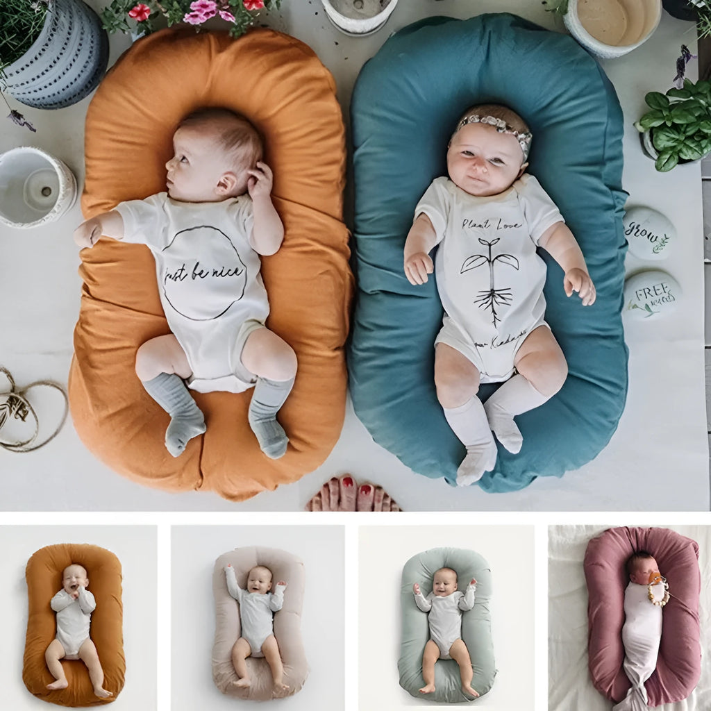 Beige portable cotton baby nest crib cushion for newborn infant sleep.
