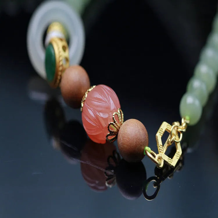Natural Hetian jade necklace with red lotus beads, white sandalwood, and beeswax accents; unisex design with fu character motif