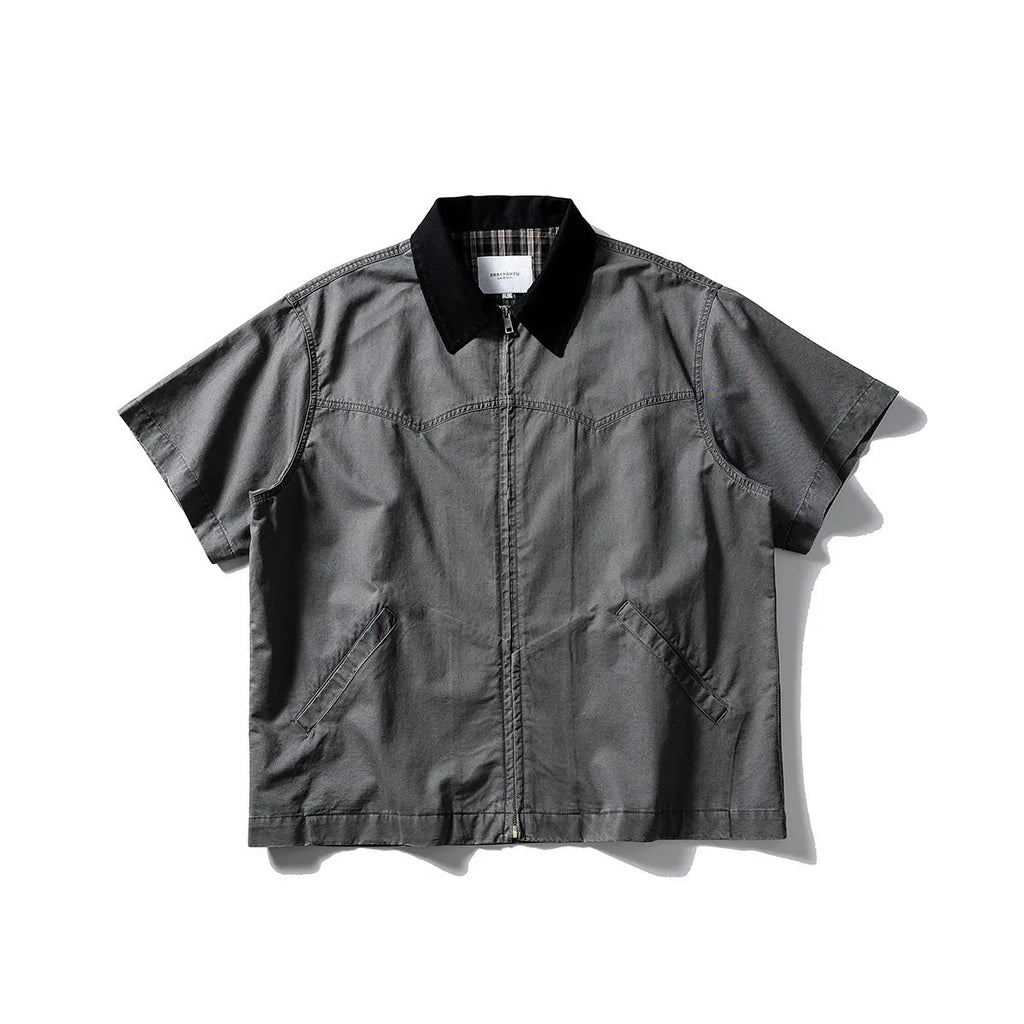 Loose grey short sleeve overalls shirt with cardigan front on a hanger.