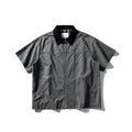 Loose grey short sleeve overalls shirt with cardigan front on a hanger.