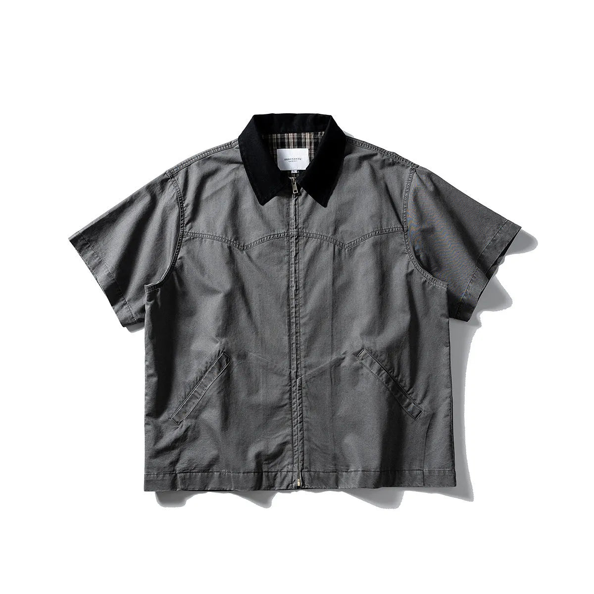 Loose grey short sleeve overalls shirt with cardigan front on a hanger.