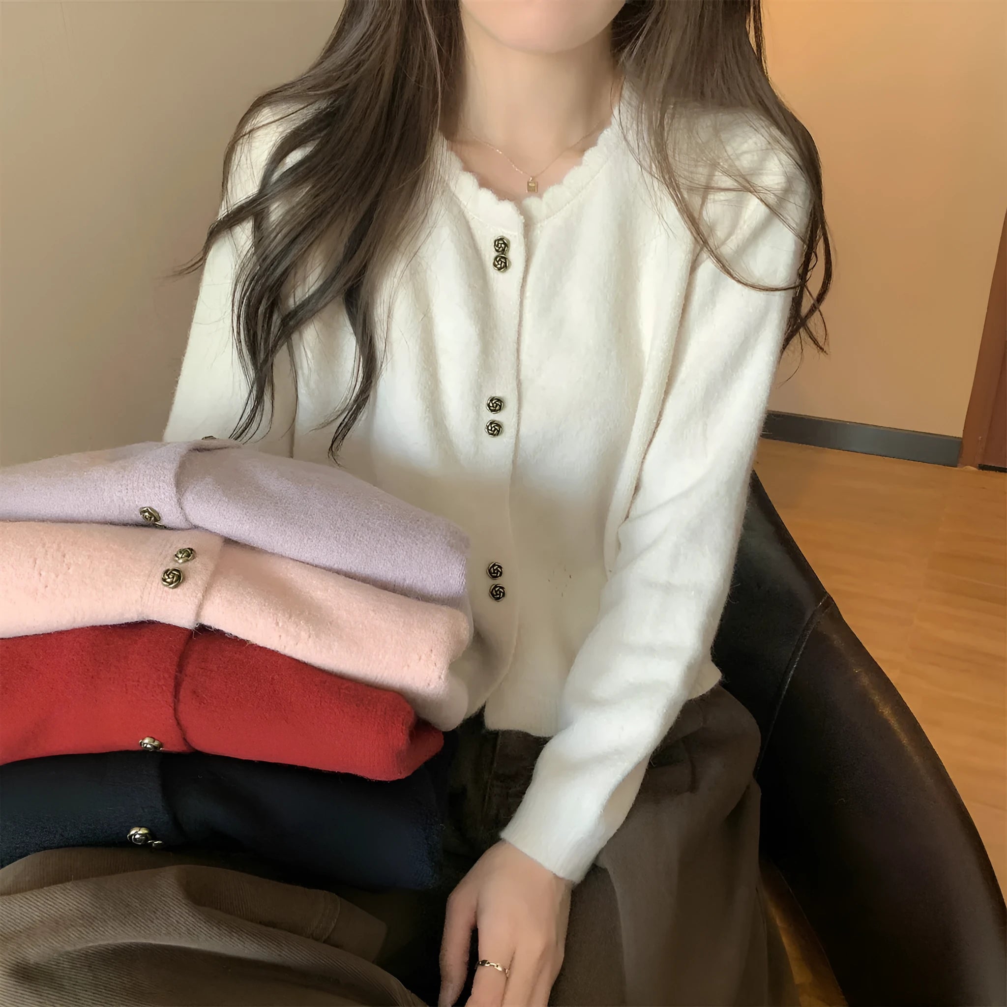 Women's long-sleeved acrylic sweater cardigan coat in milky white, shown as a layering piece.
