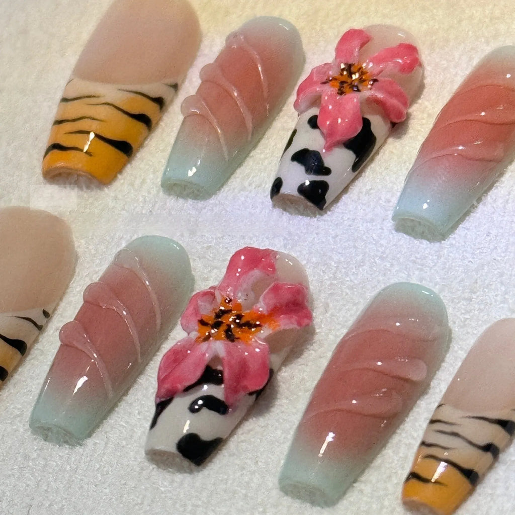 Close-up of zebra pattern artificial nails with embossed lily flower and leopard print designs, shown in long wear-resistant style.