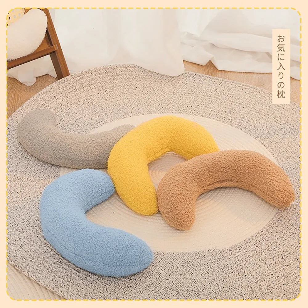 U-shaped blue cat pillow with adjustable white collar on a blanket