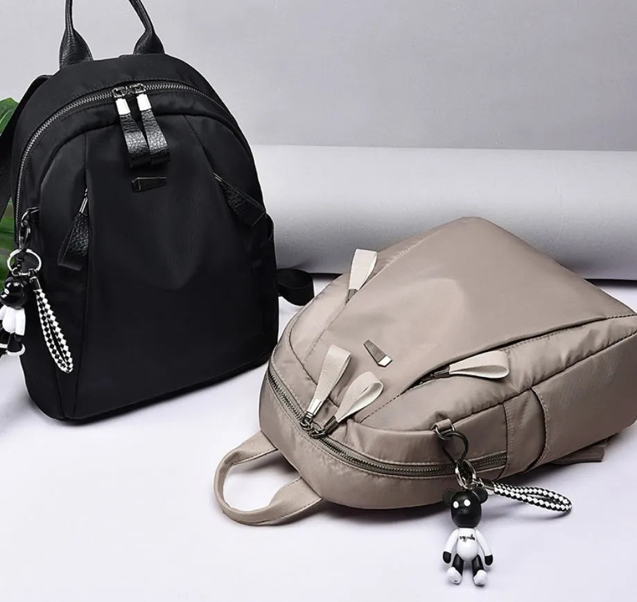 Medium square rucksack in Oxford cloth with dual straps, shown in grey colour with external digging bag.