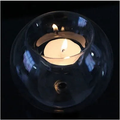 Handmade clear hollow glass sphere candle holder with tea light inside on wooden table