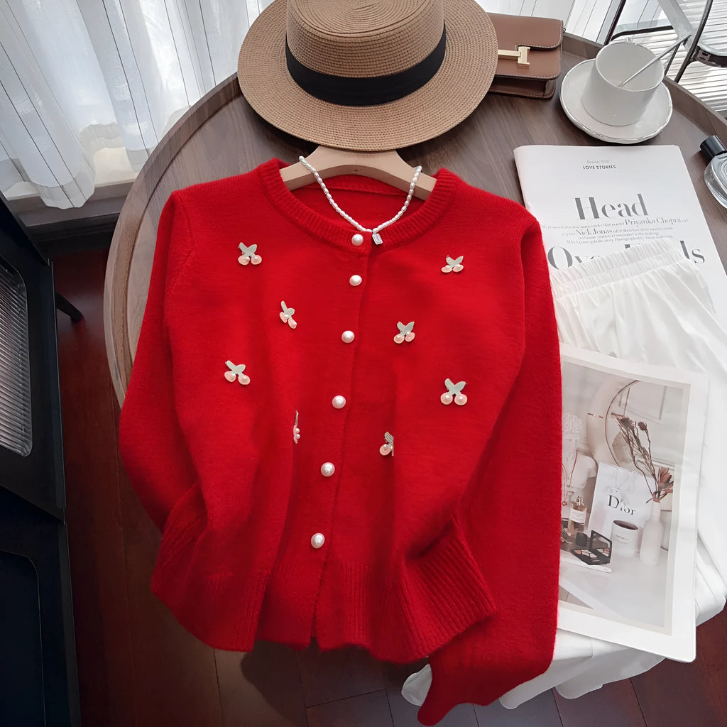 A pink cashmere blend women's cardigan sweater coat with beaded detailing and a round neck, shown open.
