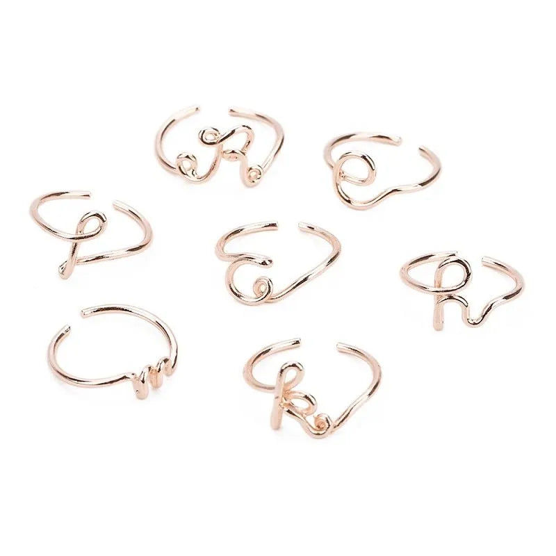 Gold coloured unisex alloy initial ring with letter A geometric shape on a flat surface